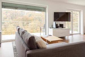 a living room with a couch and a large window at Hillhouse Novo mesto in Novo Mesto