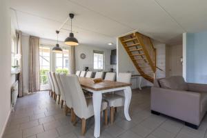 une salle à manger avec une table, des chaises et un escalier dans l'établissement Villa WaterGeluk ҉, à Susteren