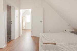 a white bedroom with a bed and a bathroom at Hillhouse Novo mesto in Novo Mesto