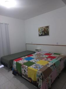 a bedroom with two beds with a quilt on them at Mares da Pinheira in Palhoça