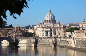 un puente sobre un río con un edificio en St. Peter Home - Your home in Rome, en Roma