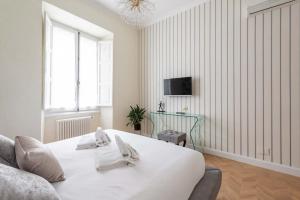 a white bedroom with a large bed and a couch at Colosseum 10steps away, Marco Aurelio Luxury House in Rome