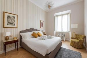 a bedroom with a large bed and a chair at Colosseum 10steps away, Marco Aurelio Luxury House in Rome