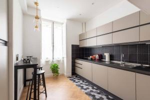 a kitchen with black and white cabinets and a table at Colosseum 10steps away, Marco Aurelio Luxury House in Rome