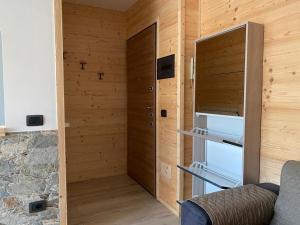 Habitación con paredes de madera y puerta con estanterías. en Casa Palabione, en Aprica