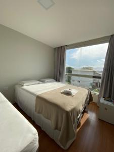 a bedroom with two beds and a large window at Pousada Ritec in Linhares +15 photos