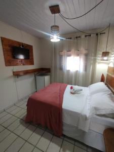 Pousada Mar e Sol في بيبا: غرفة نوم فيها سرير وتلفزيون