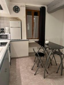 a small kitchen with a table and chairs in it at Chablis : petit studio en plein centre ville in Chablis