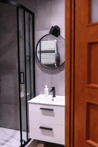 La salle de bains est pourvue d'un lavabo blanc et d'un miroir. dans l'établissement Willa Iga, à Karpacz