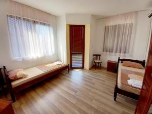 a room with a bed and two windows at Family Hotel Amore in Byala