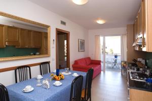 a dining room with a table and a red couch at Villa Boer in Bibione +14 photos