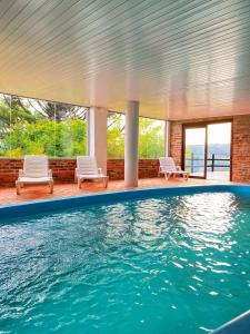 Casa con piscina con sillas y ventanas en Reserva da Collina, en Gramado