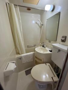 a small bathroom with a toilet and a sink at MAGURO BLDG チェックインはWhyKumano in Nachikatsuura