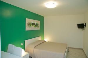 a bedroom with a bed and a green wall at Note di Colore in Sciacca