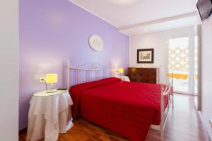 a bedroom with a red bed and a table at Villa Boer in Bibione
