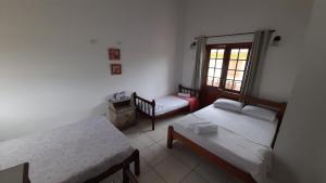 a small room with two beds and a window at Casa Show in Paraty