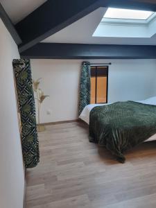 - une chambre avec un lit et une lucarne dans l'établissement Porticus saunarie, à Malaucène