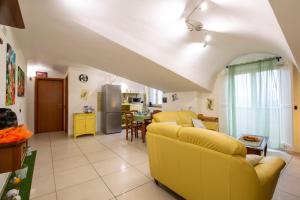 un soggiorno con mobili gialli e una cucina di B&B delle Meraviglie Salerno-Baronissi-Pellezzano a Pellezzano