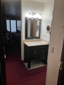 Hotel Seward في سيوارد: حمام مع حوض ومرآة