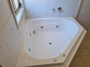 a white bath tub in a bathroom with a window at Waikerie Olive Grove in Waikerie