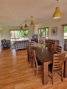 a dining room and living room with a table and chairs at Waikerie Olive Grove in Waikerie