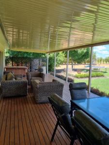 a patio with a table and chairs on a wooden deck at Waikerie Olive Grove in Waikerie