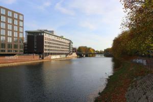 einen Fluss in einer Stadt mit Gebäuden und einer Brücke in der Unterkunft Schönes Zwei-Zimmer-Apartment in der Bremer City in Bremen