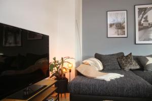 a living room with a couch and a flat screen tv at Schönes Zwei-Zimmer-Apartment in der Bremer City in Bremen