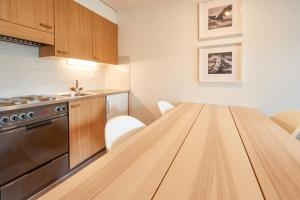 eine Küche mit einem Holztisch in der Unterkunft Cosy studio for 5 near ski lift, HAMEAU D2 in Les Collons