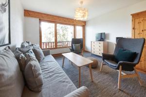 ein Wohnzimmer mit einem Sofa und 2 Stühlen in der Unterkunft Cosy studio for 5 near ski lift, HAMEAU D2 in Les Collons