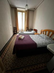 Habitación de hotel con 2 camas y toallas. en Hostal “ INFANTAS”, en Madrid