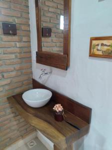 y baño con lavabo blanco y espejo. en Pousada Canto da Lua - charme e vista incrível en Carrancas