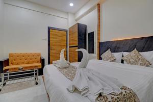 Una habitación de hotel con dos camas con cisnes. en Ivory Suites en Airoli