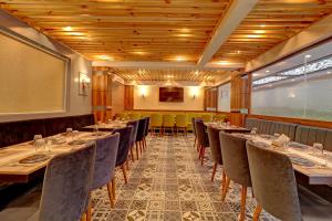 a room with tables and chairs in a restaurant at Ivory Suites in Airoli