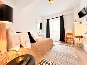 a bedroom with a bed and a table with a remote control at Hôtel du Commerce in Cluny