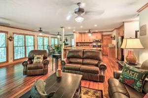 a living room with leather furniture and a table at Waterfront West Point Lake Cabin with Private Dock! in Whitewater Woods