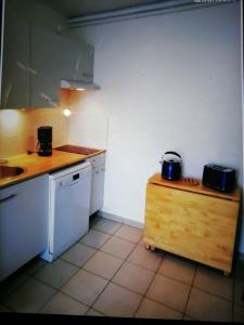 een keuken met een wastafel en een aanrecht met twee apparaten bij Bel appartement avec jardin à 50m des plages du debarquement in Bernières-sur-Mer
