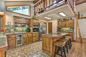a kitchen with wooden cabinets and a large island at Cozy Angel Fire Escape with Golf Course Views! in Angel Fire