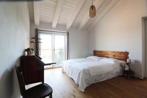 1 dormitorio con cama y ventana grande en Il Fienile di Sordevolo B&B, en Sordevolo