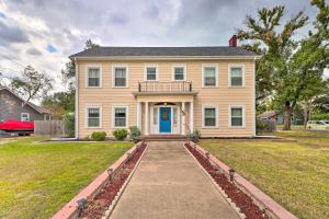 a large yellow house with a blue door at Historic 1927 Corsicana Getaway with Game Room! in Corsicana