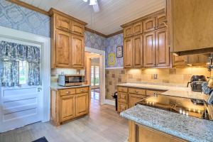 a large kitchen with wooden cabinets and a sink at Historic 1927 Corsicana Getaway with Game Room! in Corsicana