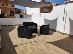 een patio met 2 stoelen en een parasol op een dak bij Belice, excepcional apartamento con Jacuzzi in Punta Umbría