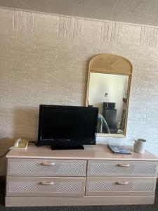 a television on a dresser in front of a mirror at Gray Wolf Lodge in Manistique