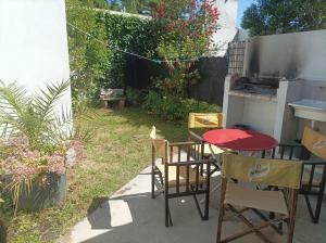 eine Terrasse mit einem Tisch und Stühlen im Hinterhof in der Unterkunft Departamentos Calasanz PB 4 in Mar del Plata