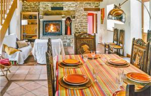 a dining room with a table and a fireplace at 3 Bedroom Stunning Home In Pont Aven in Pont-Aven