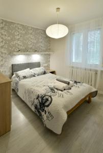 a bedroom with a bed with a comforter on it at Apartament Centrum Śródmieście in Olsztyn