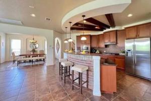 a large kitchen with a bar and a dining room at Furnished, Modern & Spacious Home - AFB Guests Special - Media Room, Self Checkin, Garage in San Antonio