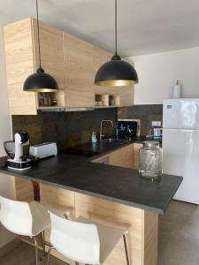 uma cozinha com um balcão preto e electrodomésticos brancos em Precioso apartamento equipado en primera línea em Múrcia