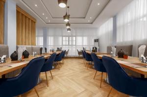 uma sala de conferências com mesas longas e cadeiras azuis em Aveon Hotel em Abuja