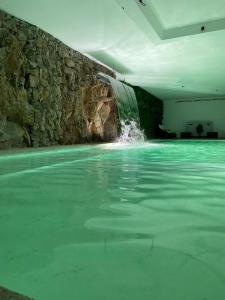 een zwembad met een waterval in een gebouw bij Douro Castelo Signature Hotel & Spa in Lamego